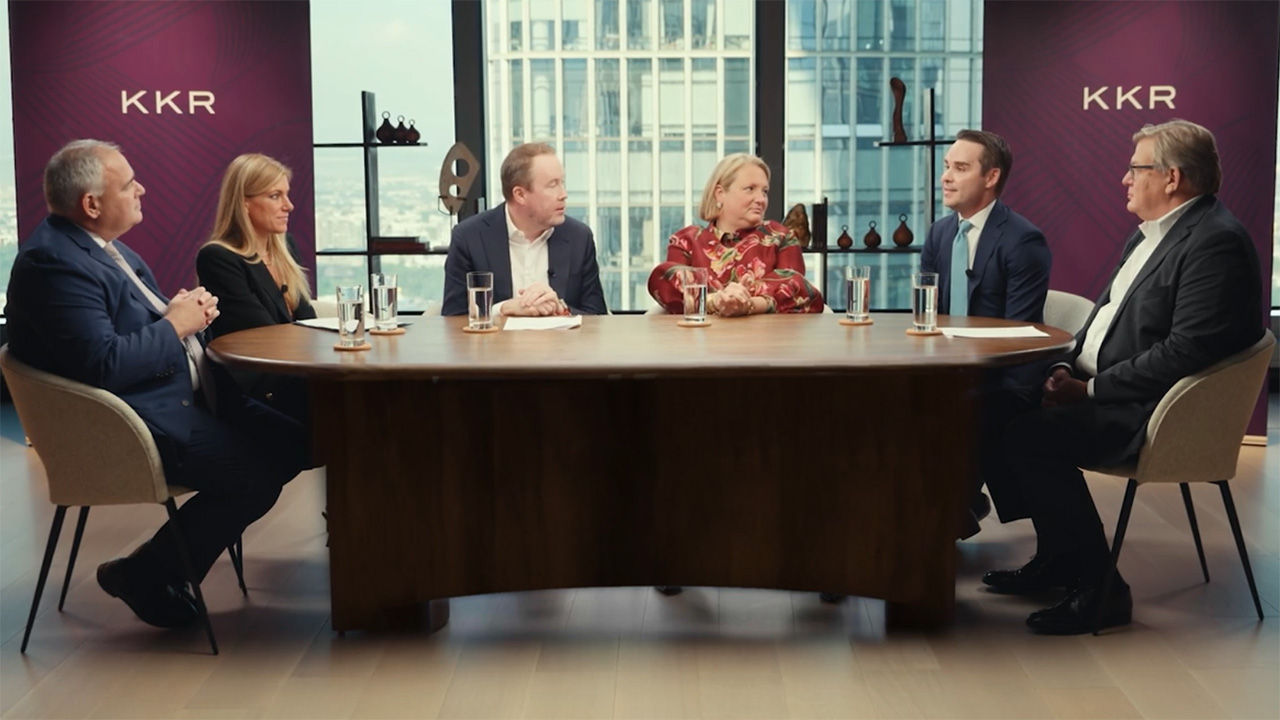 A panel of speakers sitting around a large table. 