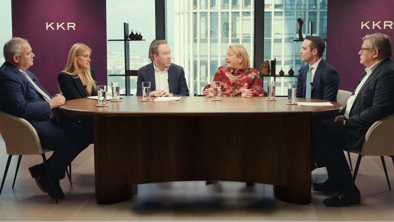A panel of speakers sitting around a large table. 